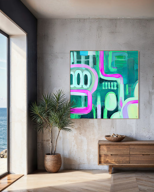 Sk8tergirl abstract fine art print by Australian artist Ash Badios, featuring vibrant turquoise, emerald green and electric pink geometric forms, displayed in a natural timber frame above a wooden sideboard in a contemporary coastal interior with textured concrete walls and ocean views.
